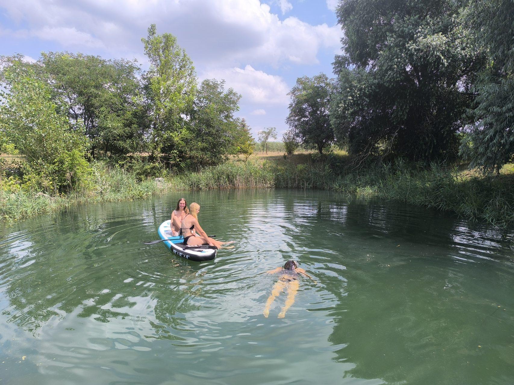 Family fun with a paddleboard on the natural swimming pond