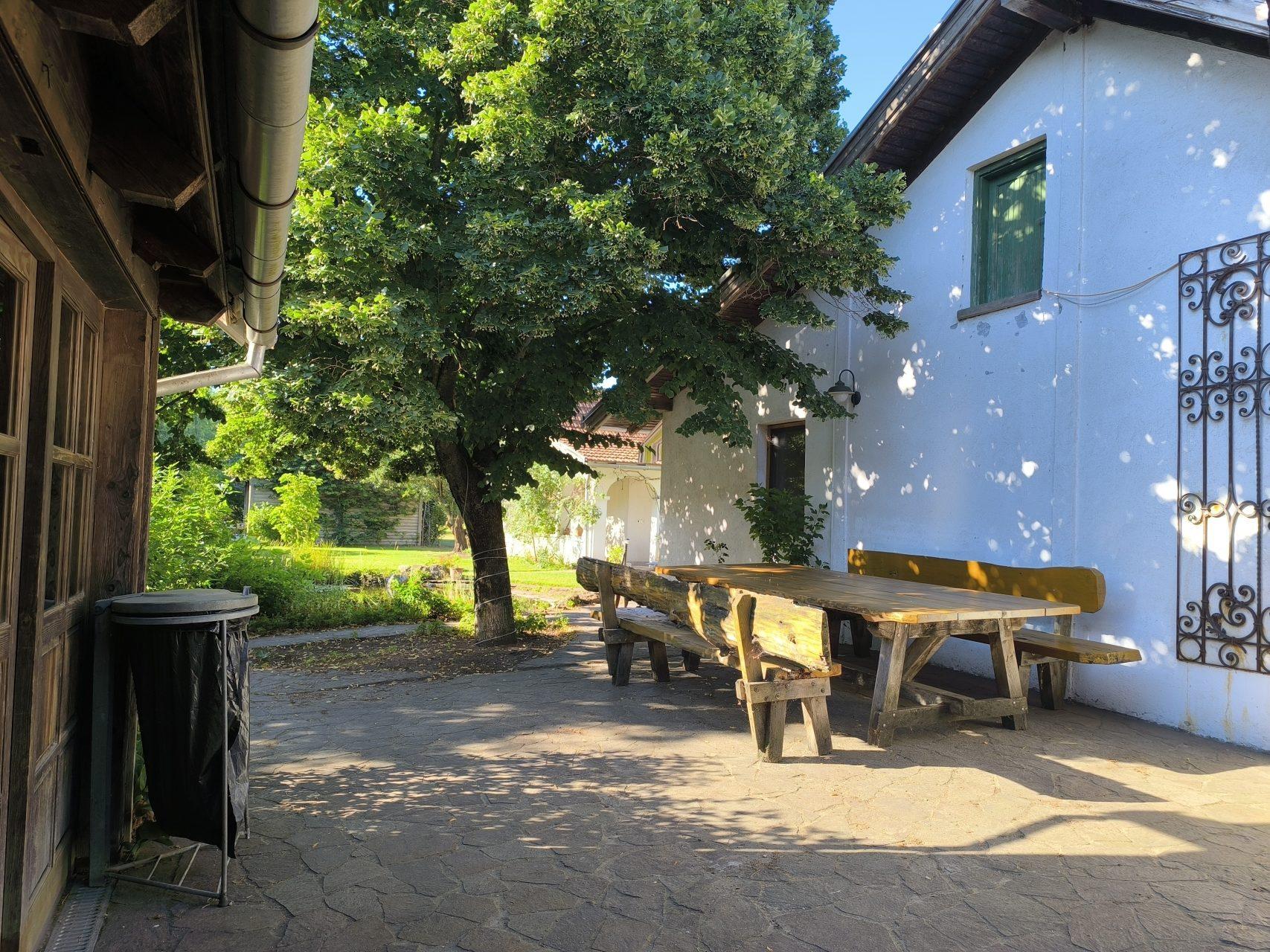 Shaded outdoor dining area with rustic wooden benches